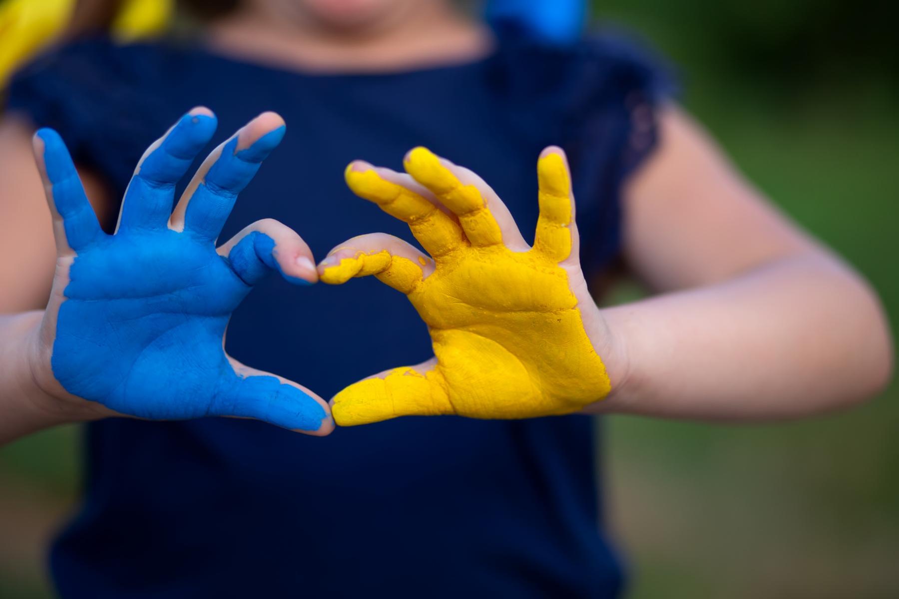Kinderhände in den Färben der Ukraine