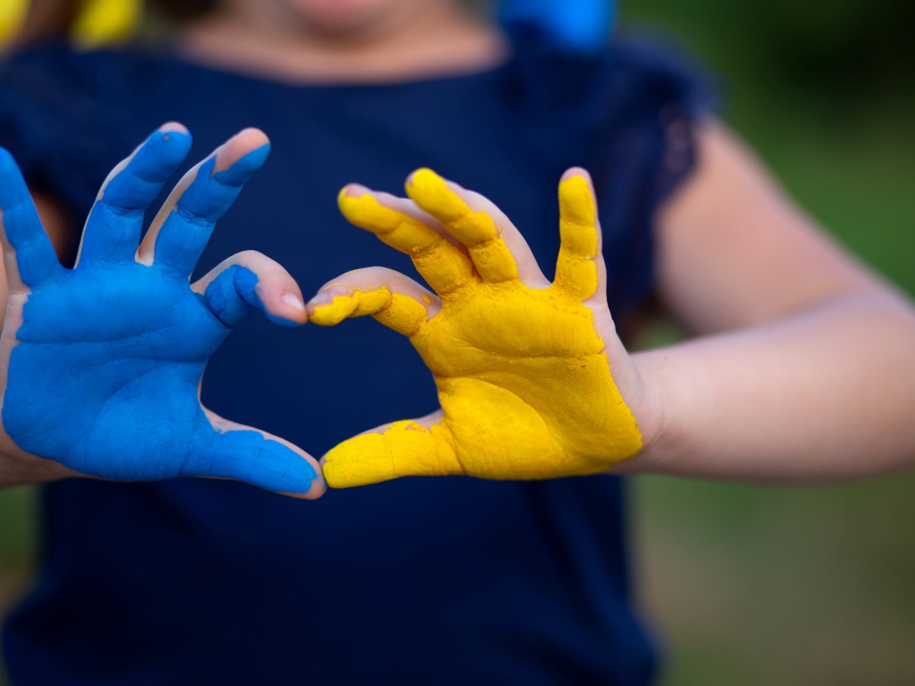 Kinderhände in den Färben der Ukraine