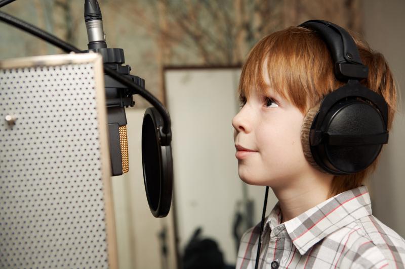 Ein rothaariger Junge spricht ins Mikrofon