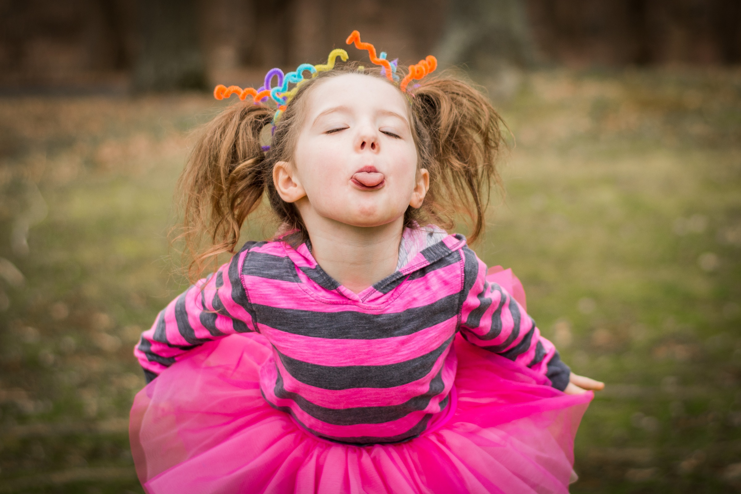 Ein Mädchen tanzt im Tütü und streckt dabei ihre Zunge heraus