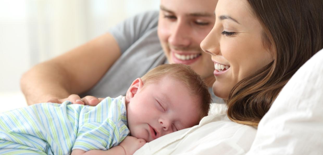 Nahaufnahme Eltern mit neugebohrenem Baby liegen im Bett