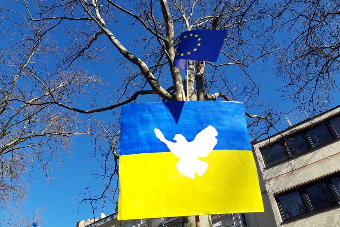 Ukrainische Fahne mit Friedenstaube auf einer Friedensdemonstration