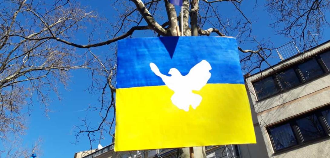 Ukrainische Fahne mit Friedenstaube auf einer Friedensdemonstration