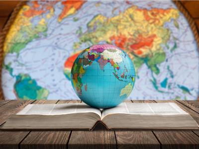 Globus auf aufgeschlagenem Buch und Weltkarte