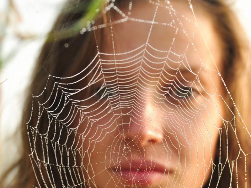 Frau hinter Spinnennetz