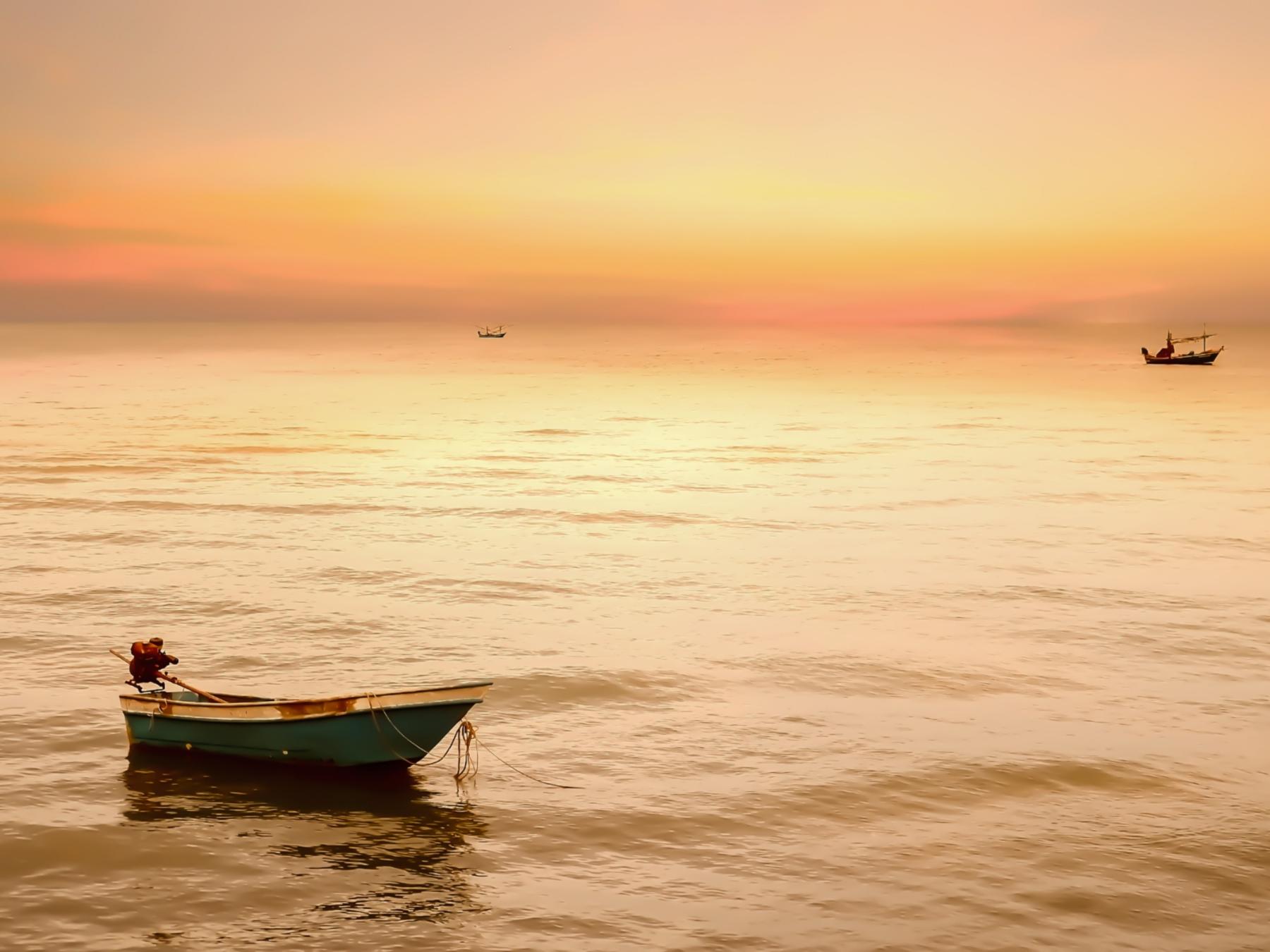 shutterstock_1482267869_ekapol sirachainan_Fischerboote_Sonnenuntergang_Meer_frei