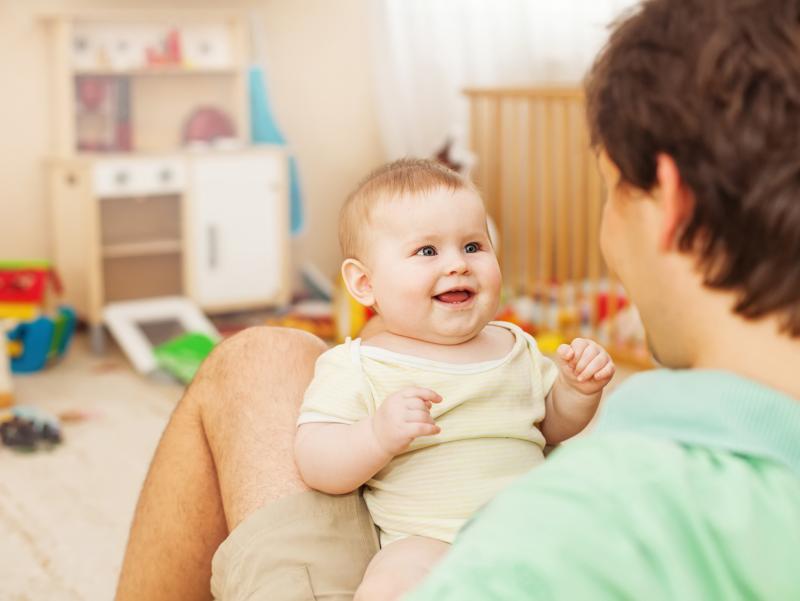 shutterstock_218714161_Kinderzimmer_Vater_hält_Baby_auf_Beinen_frei