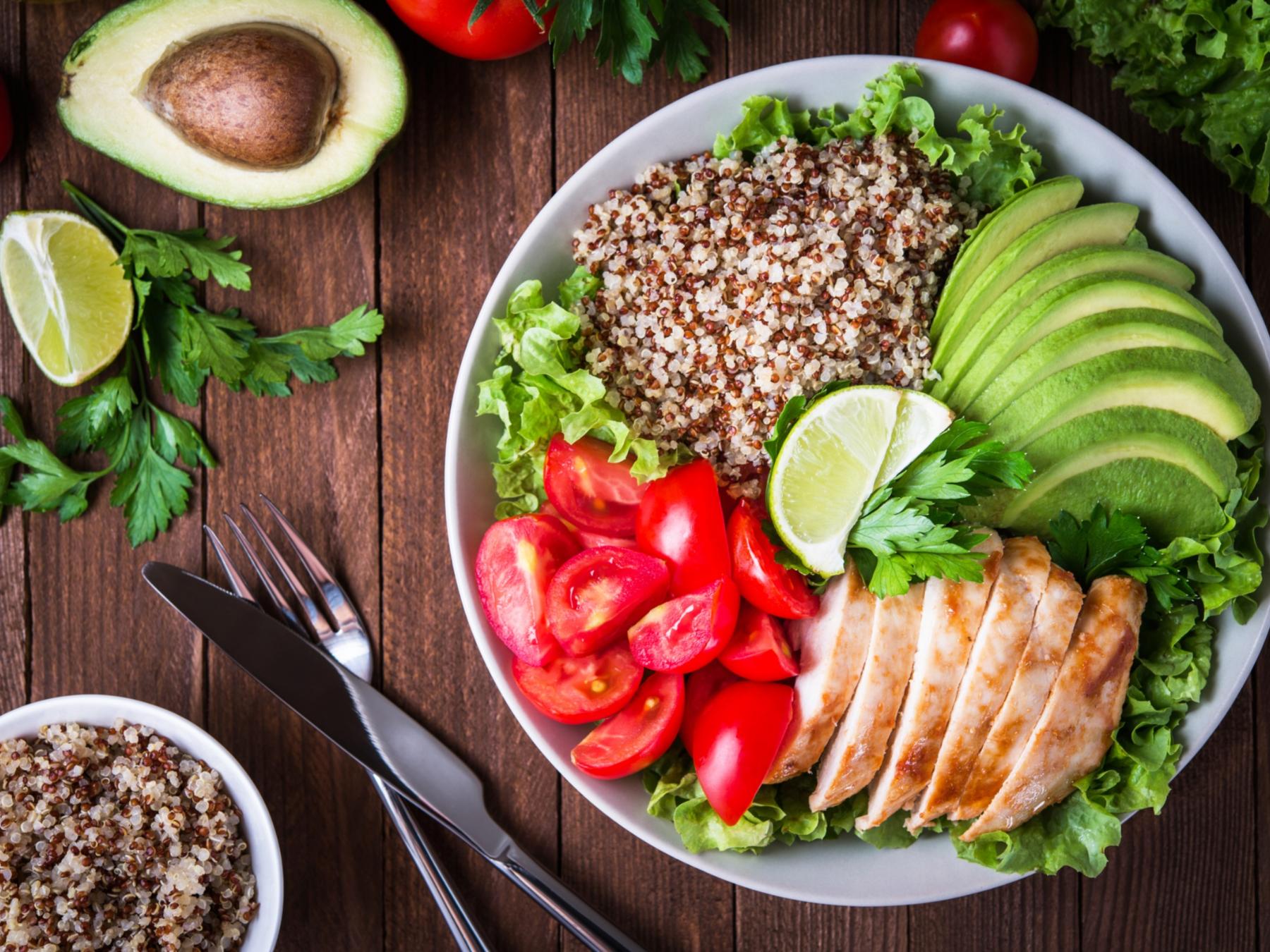 shutterstock_579577657_Elenadesign_Bowl_Quinoa_Avocado_Fleisch_Tomaten_Teller_Besteck_Vogelperspektive_frei