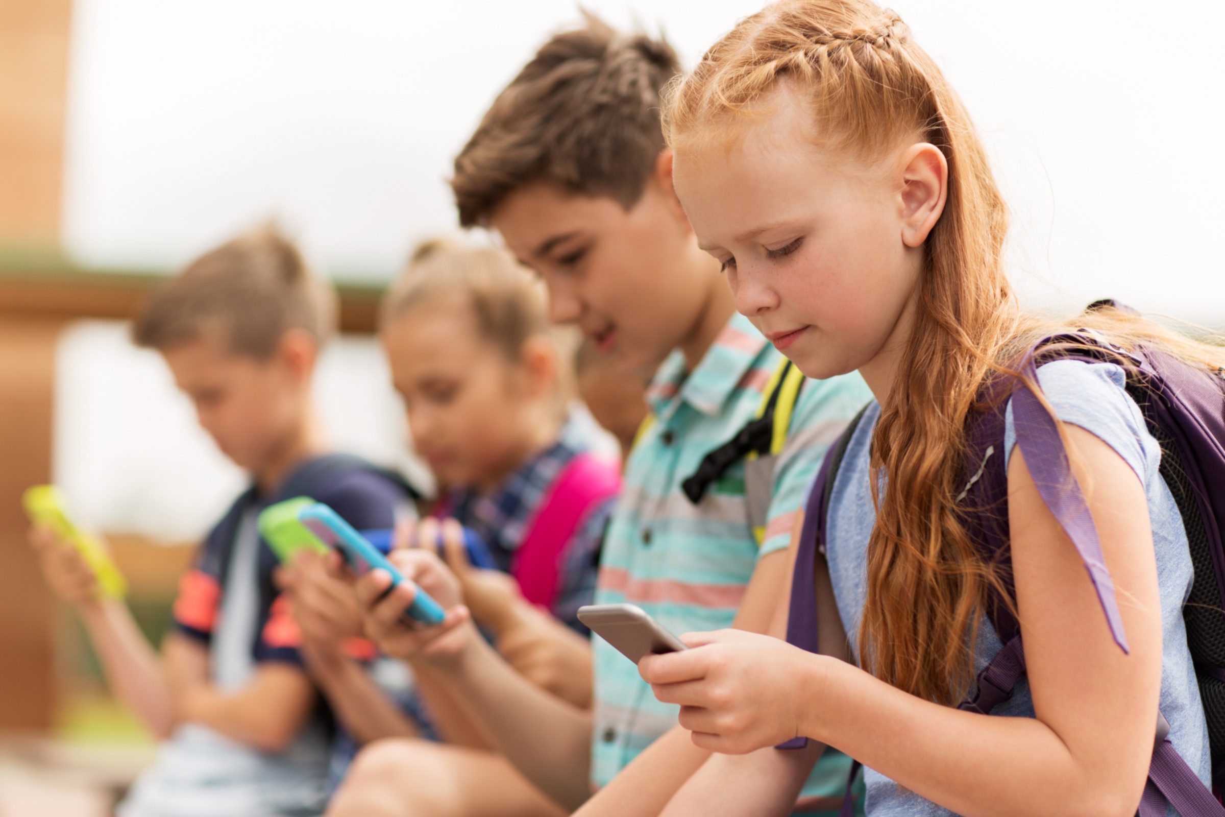 Schulkinder schauen auf das Smartphone