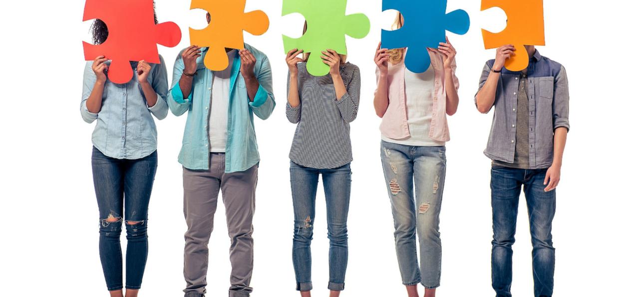 shutterstock_428443576_ GoodStudio_verschiedene_Menschen_halten_bunte_Puzzleteile_vorm_Gesicht_frei